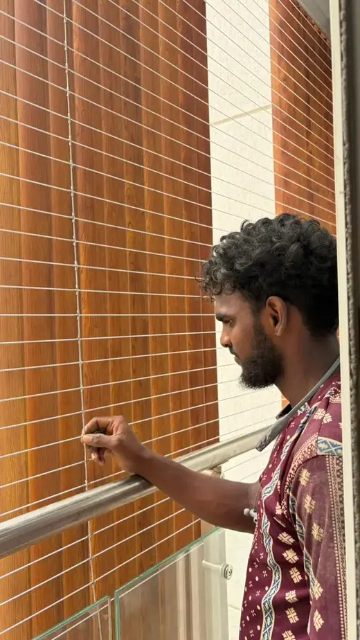 Technician tensioning SS 316 invisible grill cables during a balcony invisible grill installation in Aminjikarai, Chennai